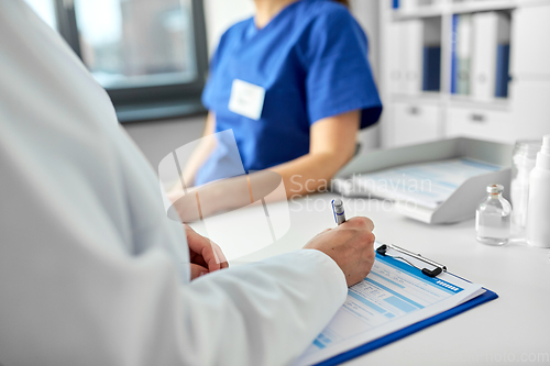 Image of doctor with clipboard and nurse at hospital
