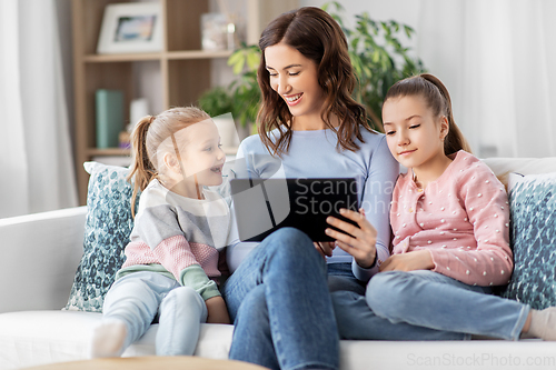 Image of happy mother and daughters with tablet pc at home