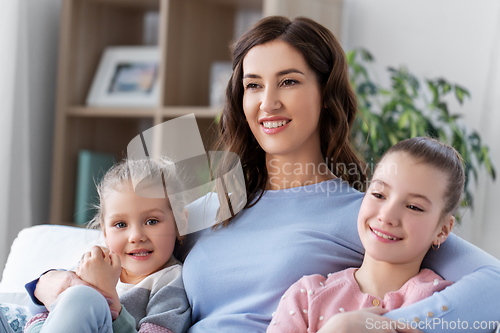 Image of happy smiling mother with two daughters at home