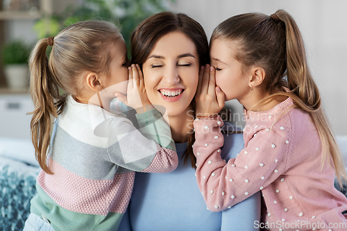 Image of happy mother and daughters gossiping at home