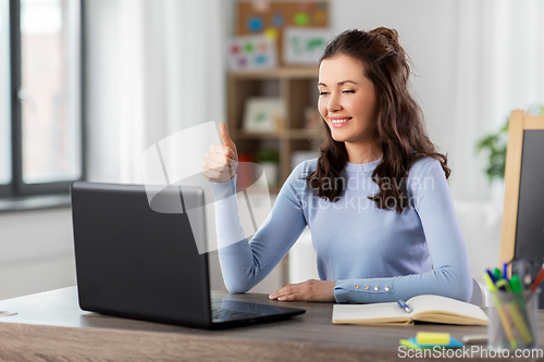 Image of teacher with laptop having online class at home