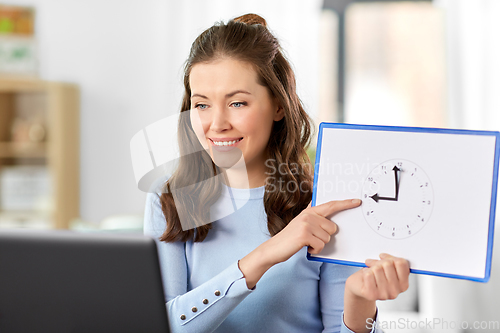 Image of teacher with clock having online class at home