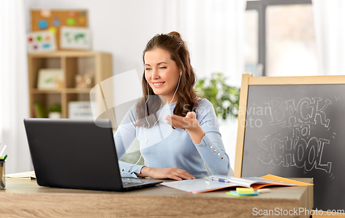 Image of teacher with laptop having online class at home