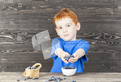 Image of child with blueberry