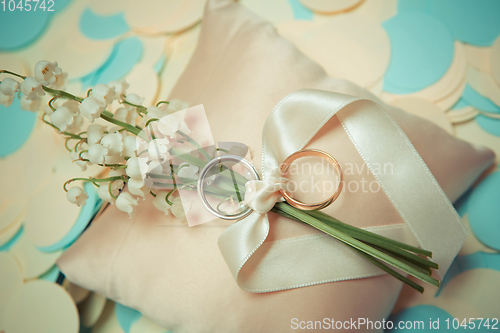 Image of white gold wedding rings with a bouquet 