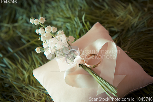 Image of white gold wedding rings with a bouquet 