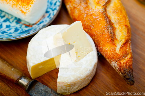 Image of French cheese and fresh  baguette on a wood cutter