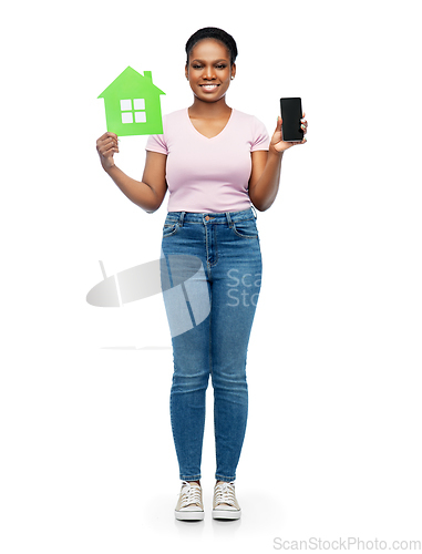 Image of african woman with smartphone and green house