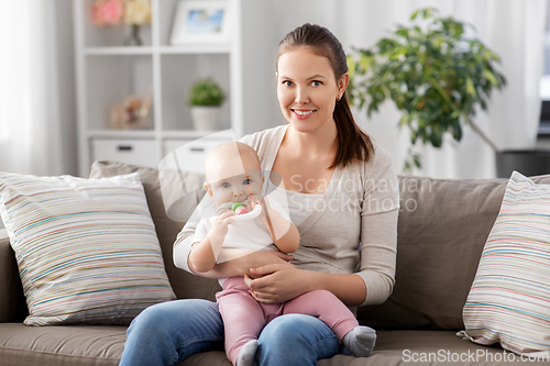 Image of mother and little baby with teething toy at home