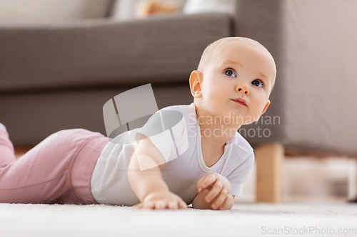 Image of little baby girl crawling on floor at home