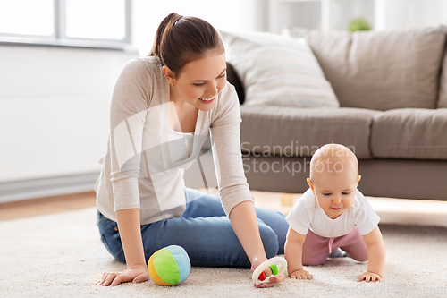 Image of happy mother playing with little baby at home