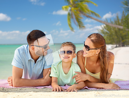 Image of happy family lying over tropical beach background