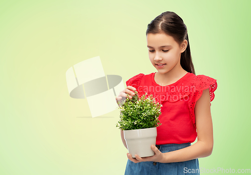 Image of happy smiling girl holding green flower in pot