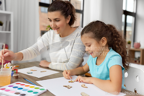 Image of happy mother with little daughter drawing at home