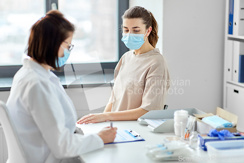 Image of doctor with clipboard and patient at hospital