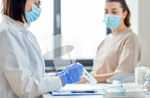 Image of female doctor with syringe and patient at hospital