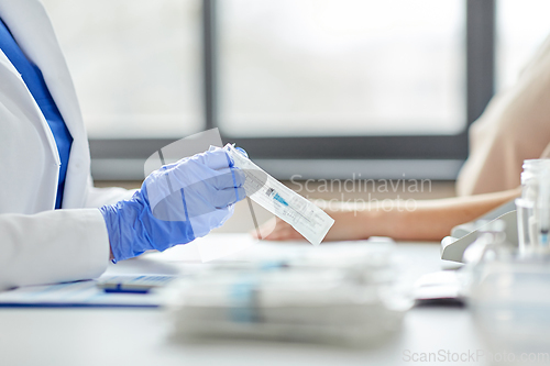 Image of female doctor with syringe and patient at hospital