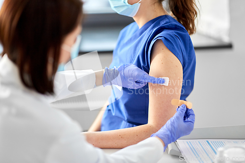 Image of doctor attaching patch to medical worker