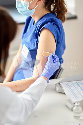 Image of doctor attaching patch to medical worker