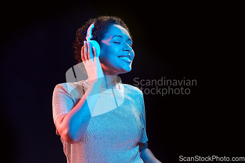 Image of woman in headphones listening to music and dancing