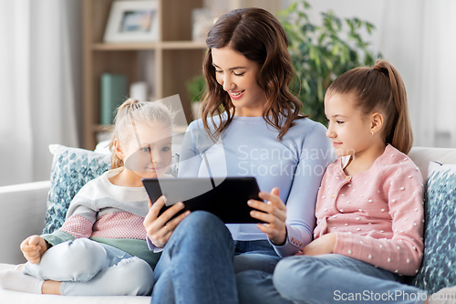 Image of happy mother and daughters with tablet pc at home