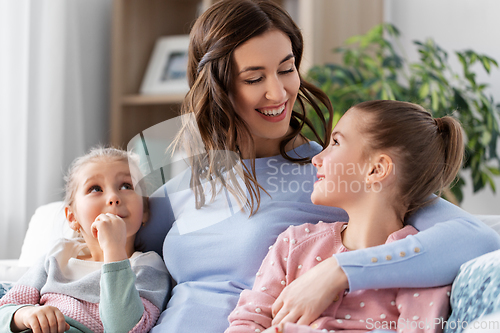 Image of happy smiling mother with two daughters at home