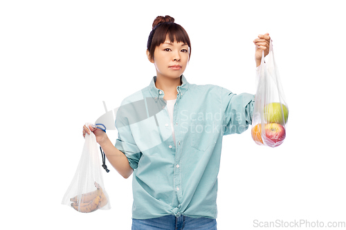 Image of woman with fruits in reusable and plastic bags