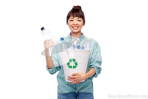 Image of smiling young asian woman sorting plastic waste