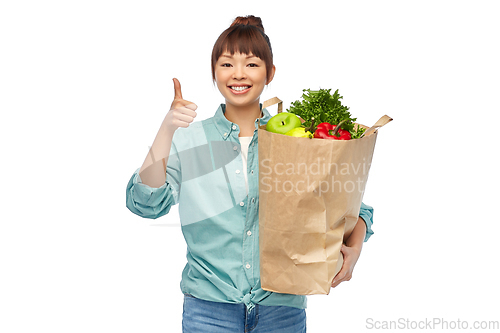Image of happy asian woman with food in paper shopping bag