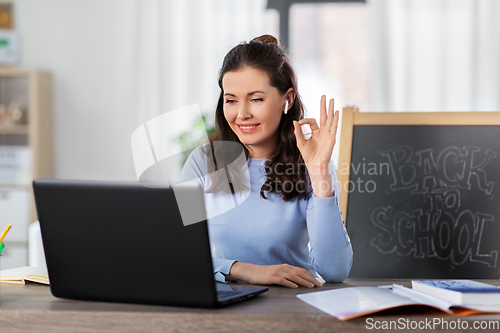 Image of teacher with laptop having online class at home