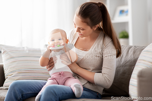 Image of mother and little baby with teething toy at home