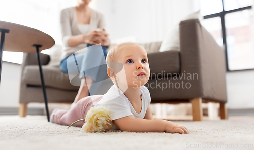 Image of mother and baby crawling on floor at home