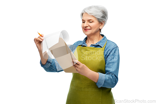 Image of smiling old woman in garden apron with clipboard