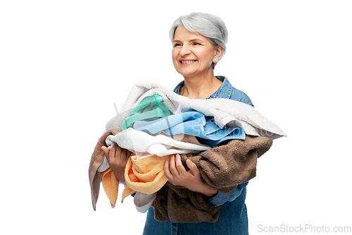 Image of smiling senior woman with heap of bath towels