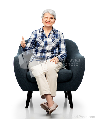 Image of old woman sitting in chair and showing thumbs up