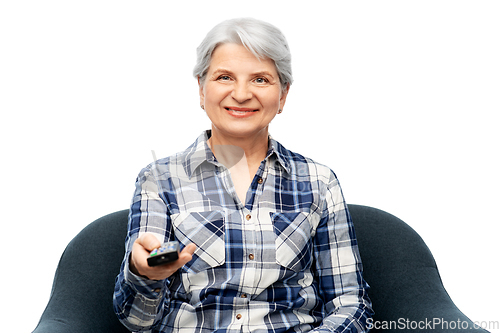 Image of happy senior woman watching tv sitting in armchair