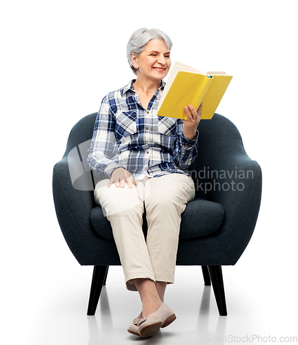 Image of senior woman reading book sitting in armchair