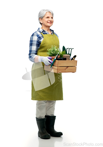 Image of smiling senior woman with garden tools in box