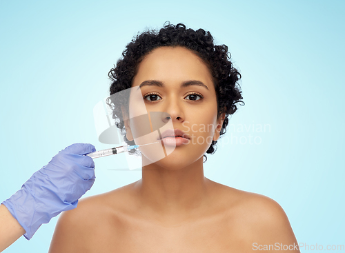 Image of face of african woman and hand with syringe