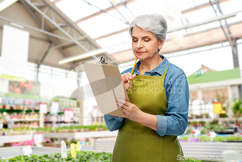 Image of senior woman with clipboard at garden store