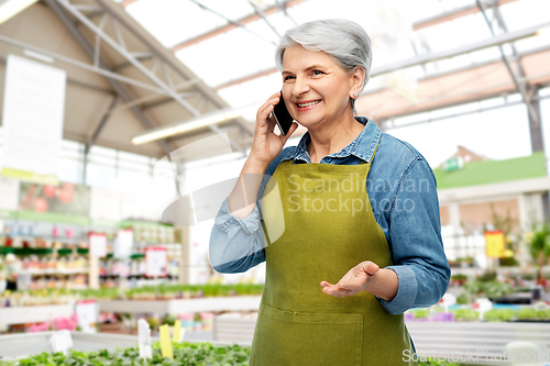 Image of senior woman calling on smartphone at garden store