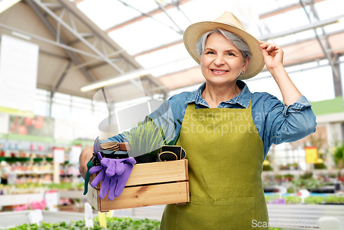 Image of senior woman with tools in box at garden store