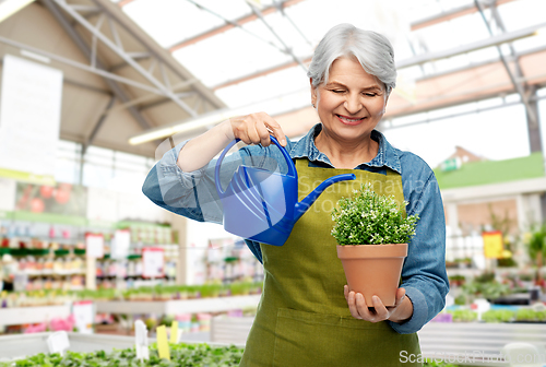 Image of senior gardener with flower and watering can