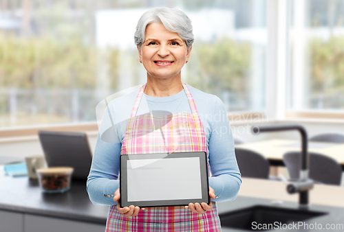 Image of happy senior woman in apron with tablet pc at home