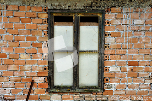 Image of stained brick wall and boarded up window