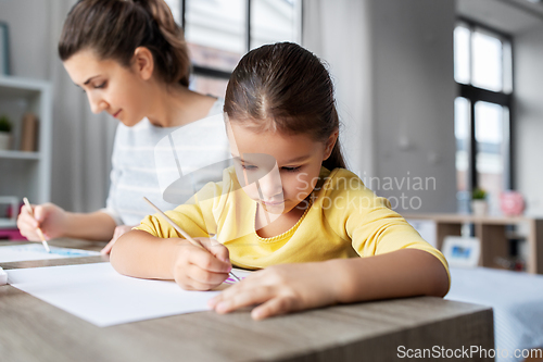 Image of mother with little daughter drawing at home