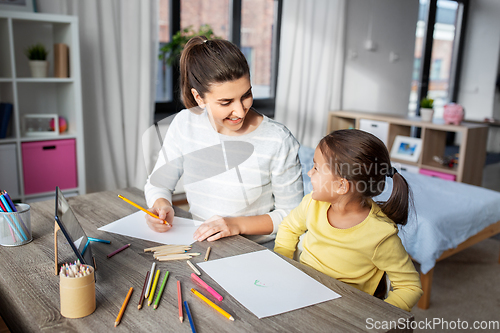 Image of mother with little daughter drawing at home