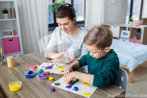 Image of mother and son playing with modeling clay at home