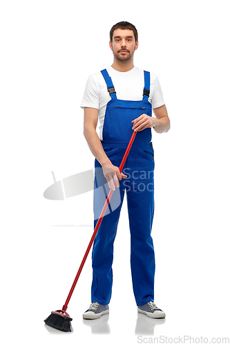 Image of male cleaner in overall cleaning floor with broom