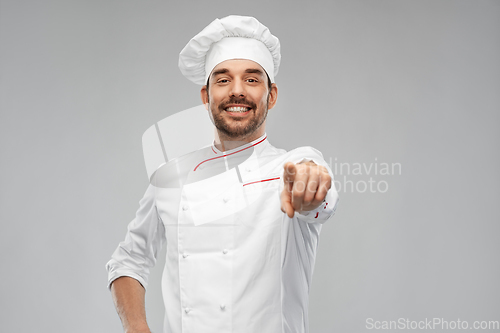 Image of happy smiling male chef in toque pointing to you